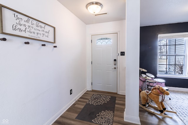 foyer entrance with wood finished floors, visible vents, and baseboards