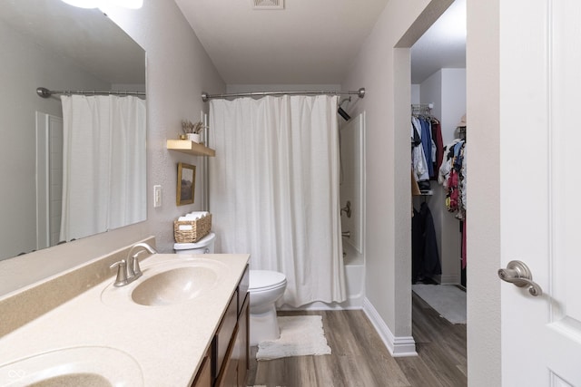 full bathroom with double vanity, visible vents, toilet, wood finished floors, and a sink