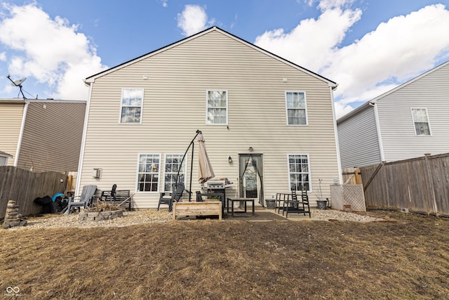 rear view of house featuring a fenced backyard and a patio