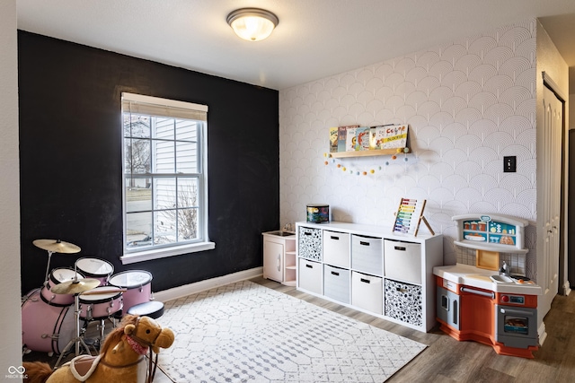 game room featuring wood finished floors, vaulted ceiling, baseboards, and wallpapered walls