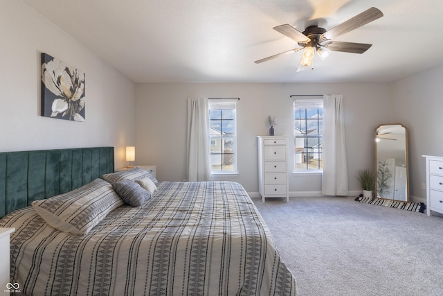 carpeted bedroom with ceiling fan and baseboards