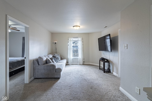 carpeted living area featuring visible vents, a textured wall, and baseboards