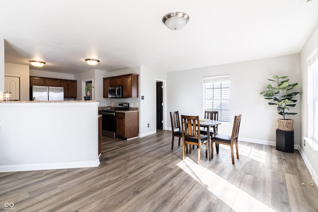 dining space with light wood-style flooring and baseboards