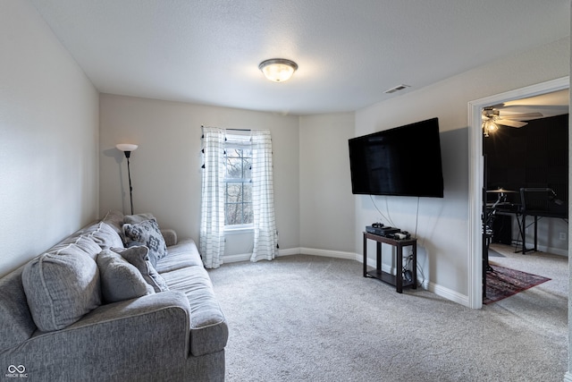 living room with carpet, a textured ceiling, visible vents, and baseboards