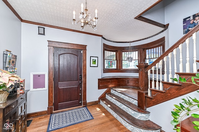 foyer featuring stairway, crown molding, and baseboards