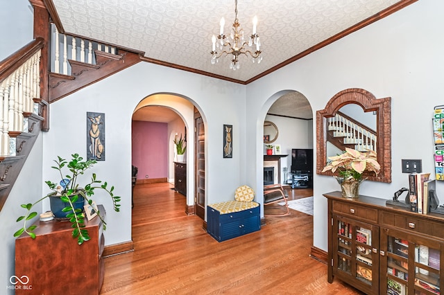 corridor featuring ornamental molding, an ornate ceiling, baseboards, and wood finished floors