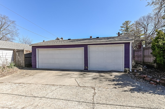 detached garage featuring fence