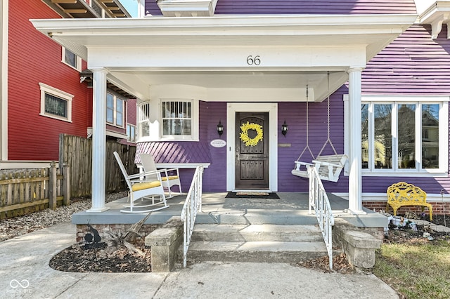 property entrance featuring a porch and fence