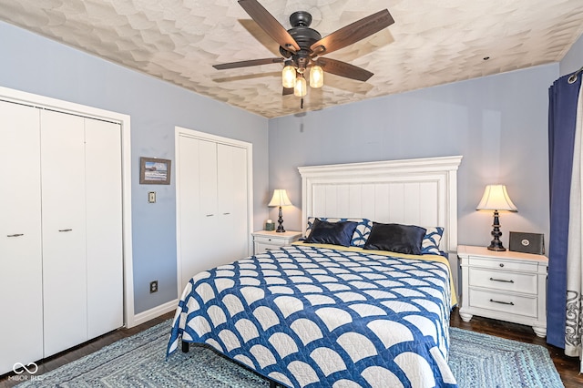 bedroom with ceiling fan, baseboards, multiple closets, wood finished floors, and a textured ceiling