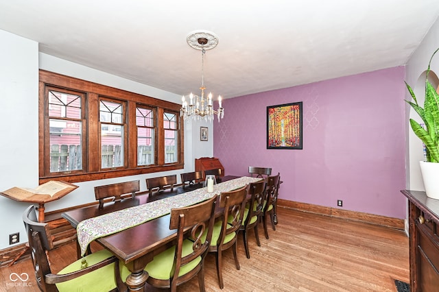 dining room with visible vents, light wood-style flooring, baseboards, and an inviting chandelier