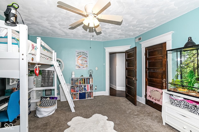 carpeted bedroom with a textured ceiling, baseboards, visible vents, and ceiling fan