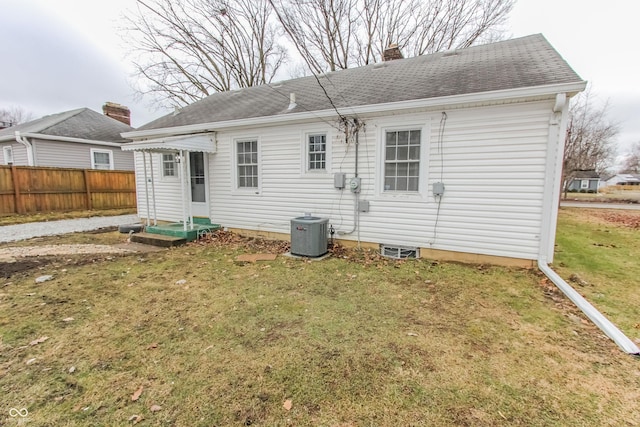 back of house featuring central AC and a lawn