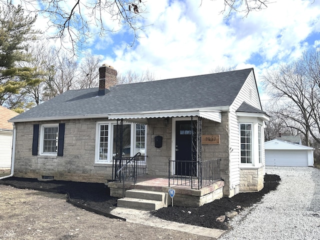 view of front of house with covered porch, roof with shingles, an outdoor structure, and a chimney