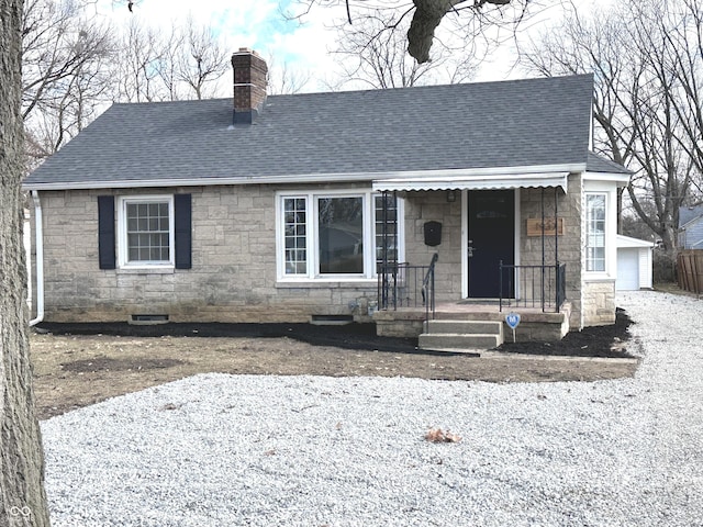 view of front facade featuring stone siding, roof with shingles, a chimney, and an outdoor structure