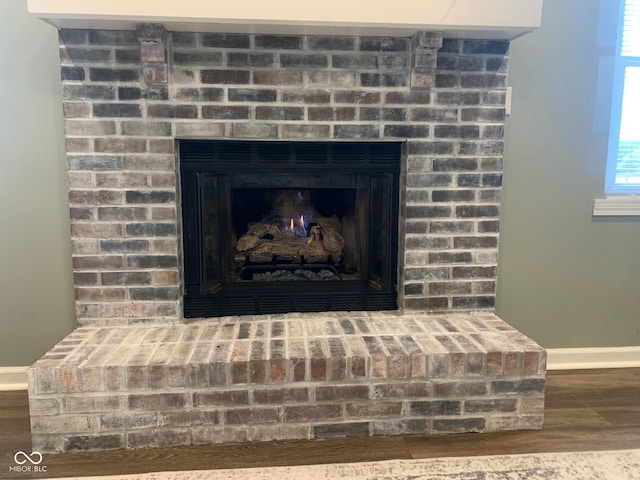 details featuring hardwood / wood-style flooring and a brick fireplace