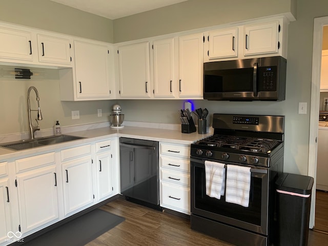 kitchen with white cabinetry, stainless steel appliances, dark hardwood / wood-style floors, and sink