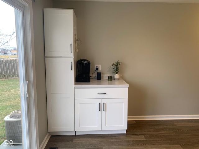 bar featuring white cabinetry and dark hardwood / wood-style flooring