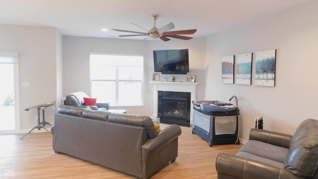 living room featuring light hardwood / wood-style floors and ceiling fan