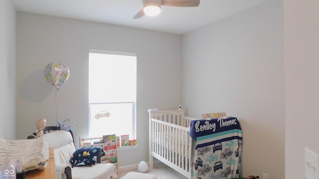 bedroom with a crib and ceiling fan