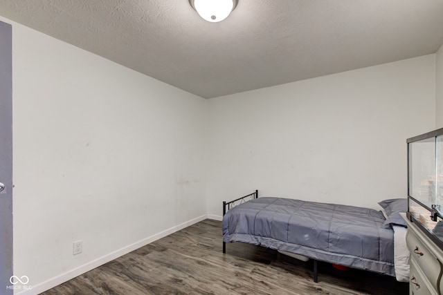 bedroom with hardwood / wood-style floors and a textured ceiling