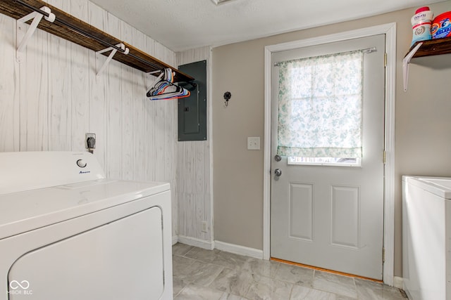 laundry room featuring electric panel, washer and clothes dryer, and a textured ceiling