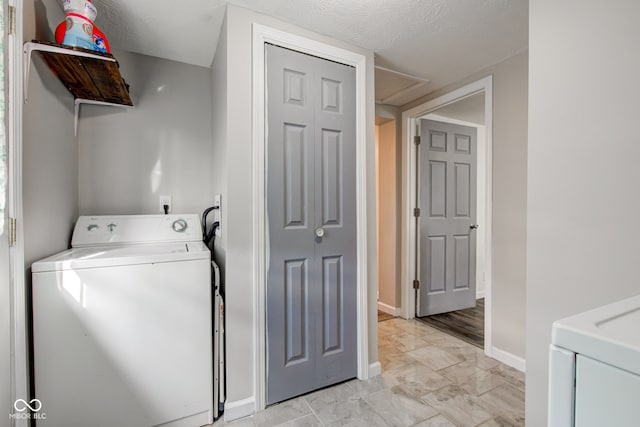 laundry room featuring washer / dryer and a textured ceiling