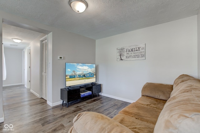 living room with hardwood / wood-style floors and a textured ceiling