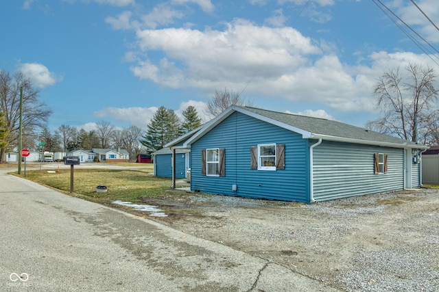 view of side of home featuring a garage and a yard