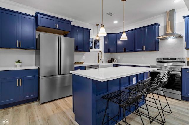 kitchen featuring a breakfast bar area, blue cabinetry, stainless steel appliances, a kitchen island, and wall chimney exhaust hood