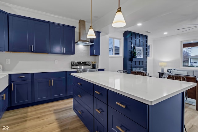 kitchen with blue cabinets, a kitchen island, wall chimney range hood, and stainless steel electric range