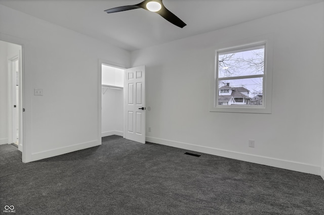 unfurnished bedroom featuring a closet, ceiling fan, and dark colored carpet