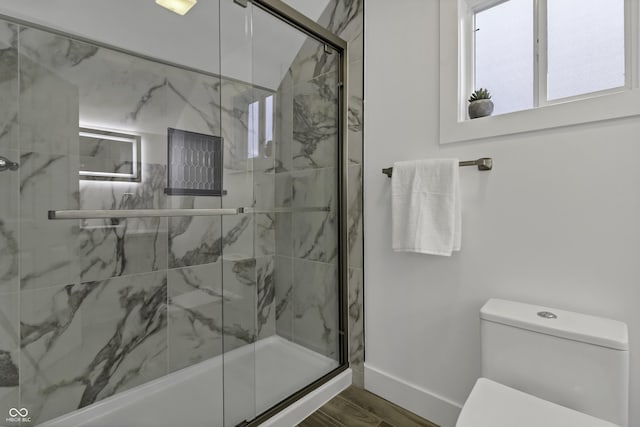 bathroom featuring wood-type flooring, toilet, and an enclosed shower