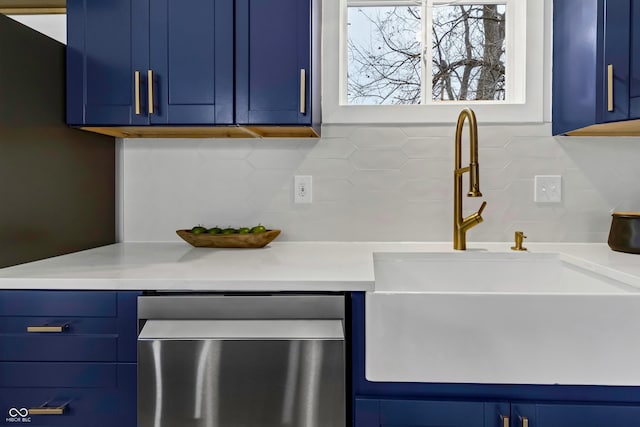 kitchen featuring dishwasher, blue cabinetry, sink, and backsplash