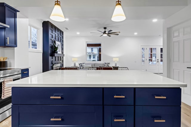 kitchen with electric stove, hanging light fixtures, blue cabinetry, and a center island