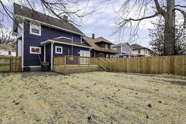 back of house with a wooden deck, a yard, and central AC