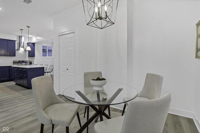 dining area with crown molding and light hardwood / wood-style floors