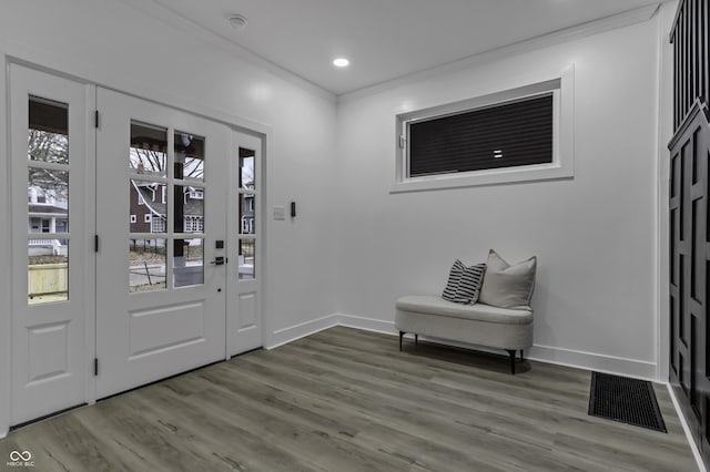 entryway with hardwood / wood-style flooring and crown molding