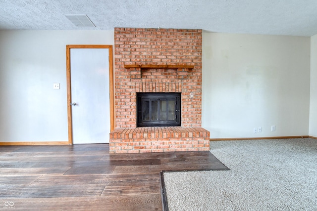 unfurnished living room featuring dark hardwood / wood-style floors, a fireplace, and a textured ceiling