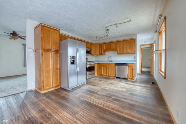 kitchen featuring sink, stainless steel appliances, dark hardwood / wood-style floors, and a textured ceiling