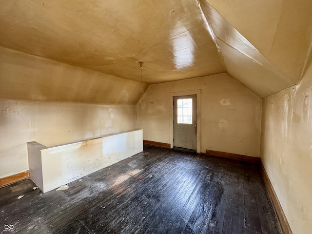 additional living space featuring lofted ceiling and dark hardwood / wood-style flooring