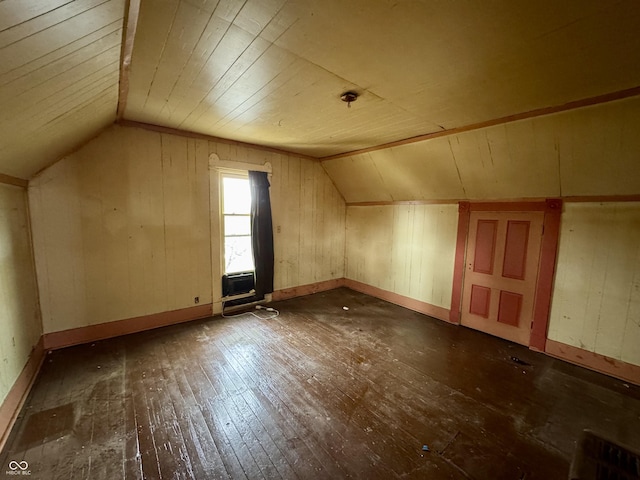 additional living space featuring wooden walls, dark hardwood / wood-style floors, vaulted ceiling, and wooden ceiling