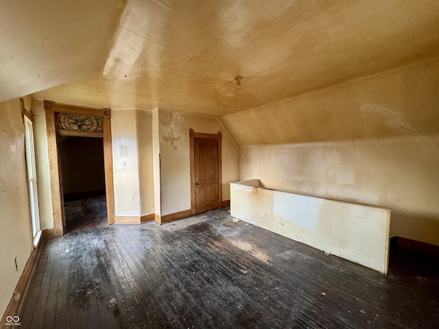 bonus room with dark hardwood / wood-style flooring and vaulted ceiling