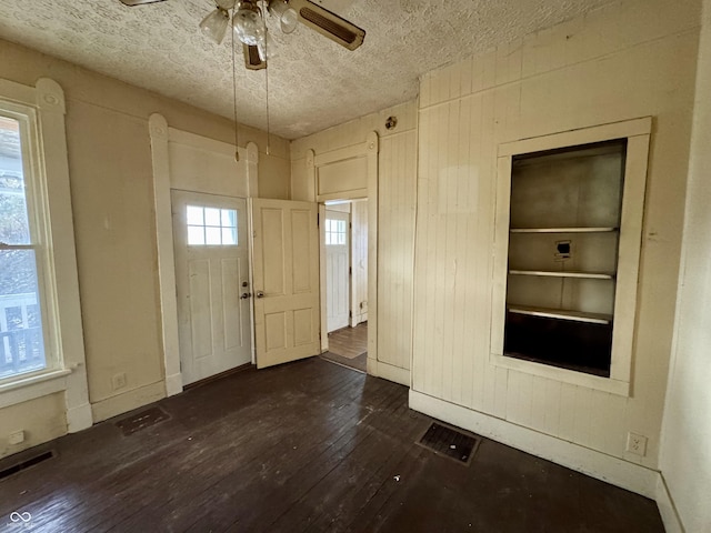 foyer with ceiling fan, dark wood-type flooring, and a textured ceiling