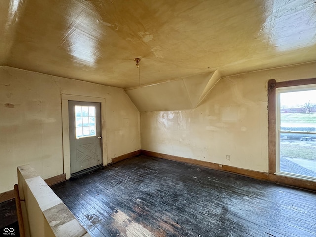 additional living space featuring lofted ceiling and dark hardwood / wood-style flooring