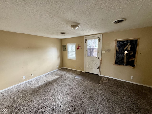 foyer with dark colored carpet and a textured ceiling