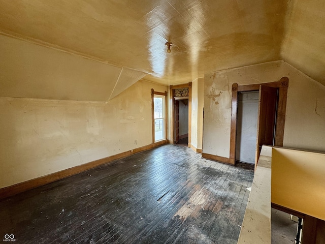 additional living space with dark hardwood / wood-style flooring and lofted ceiling