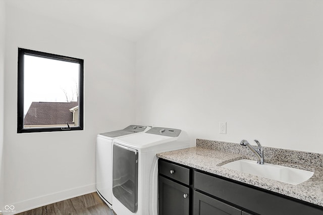 laundry room featuring cabinets, independent washer and dryer, dark wood-type flooring, and sink