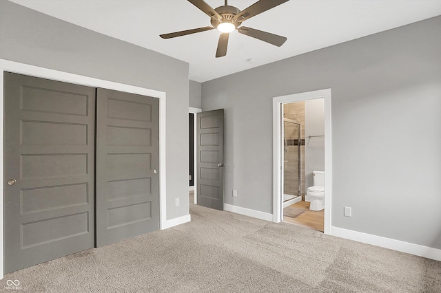 unfurnished bedroom featuring ceiling fan, light colored carpet, ensuite bath, and a closet