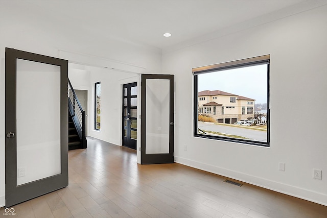 unfurnished room with wood-type flooring and french doors