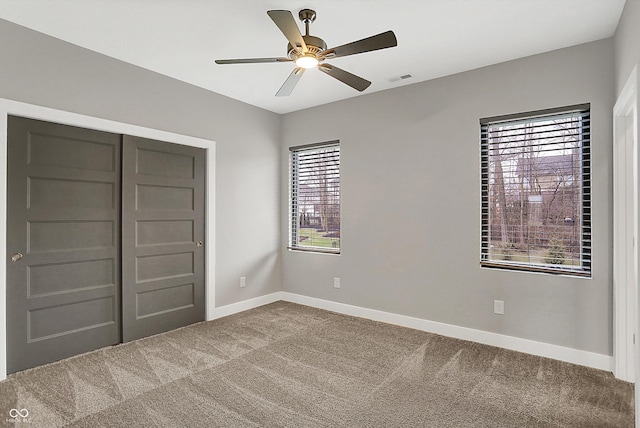 unfurnished bedroom with carpet flooring, ceiling fan, and a closet